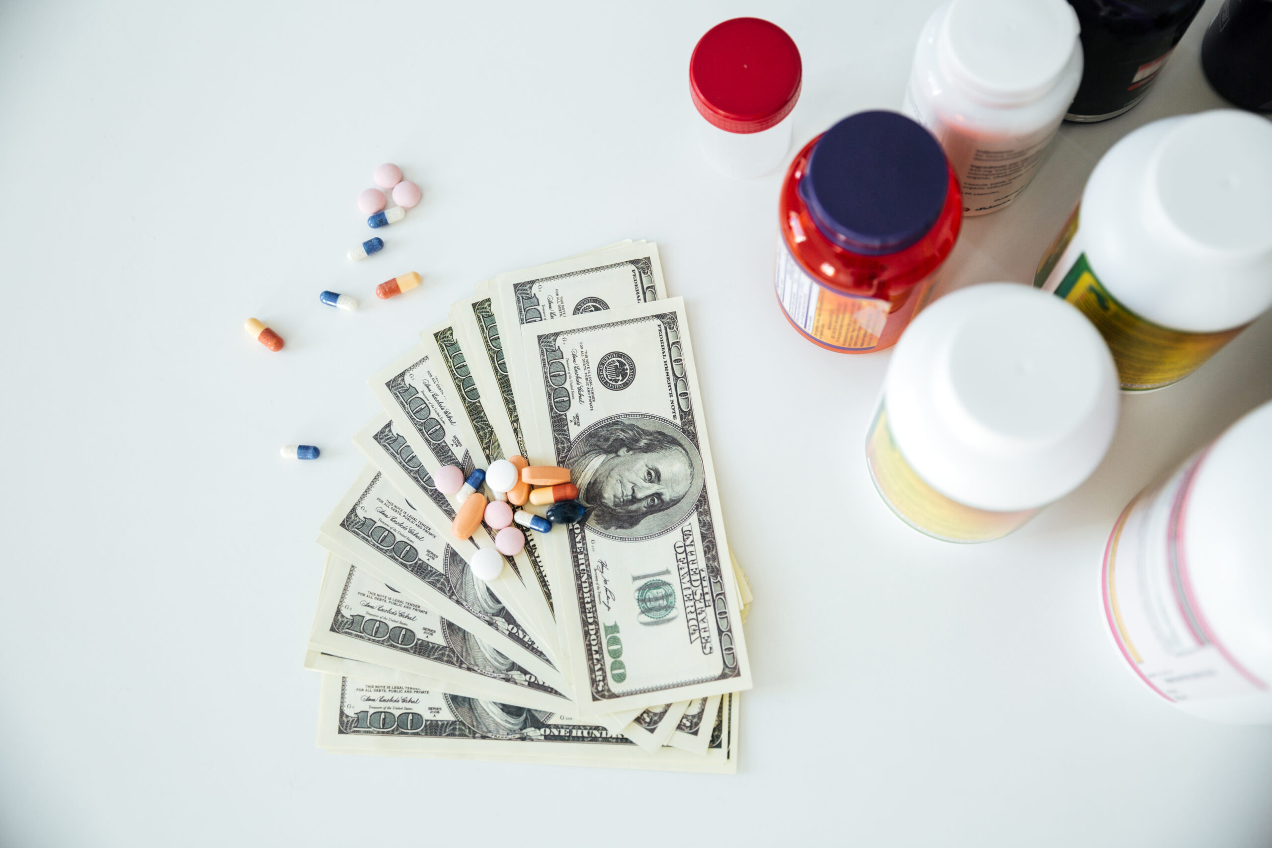 Picture of money with pills and vitamins over white background